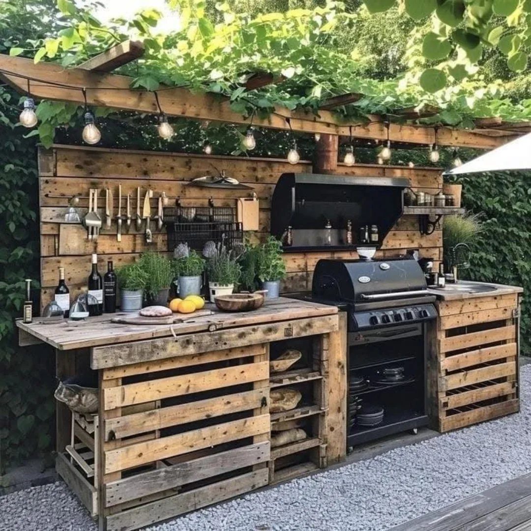 A rustic outdoor kitchen station constructed from wooden pallets featuring a grill and countertop.